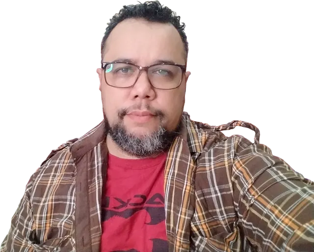 Lenin Peralta sonriendo, con camisa a cuadros